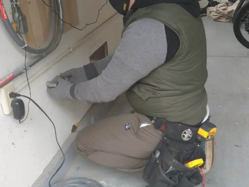 Electrician performing outlet wiring in a Wolf Trap garage